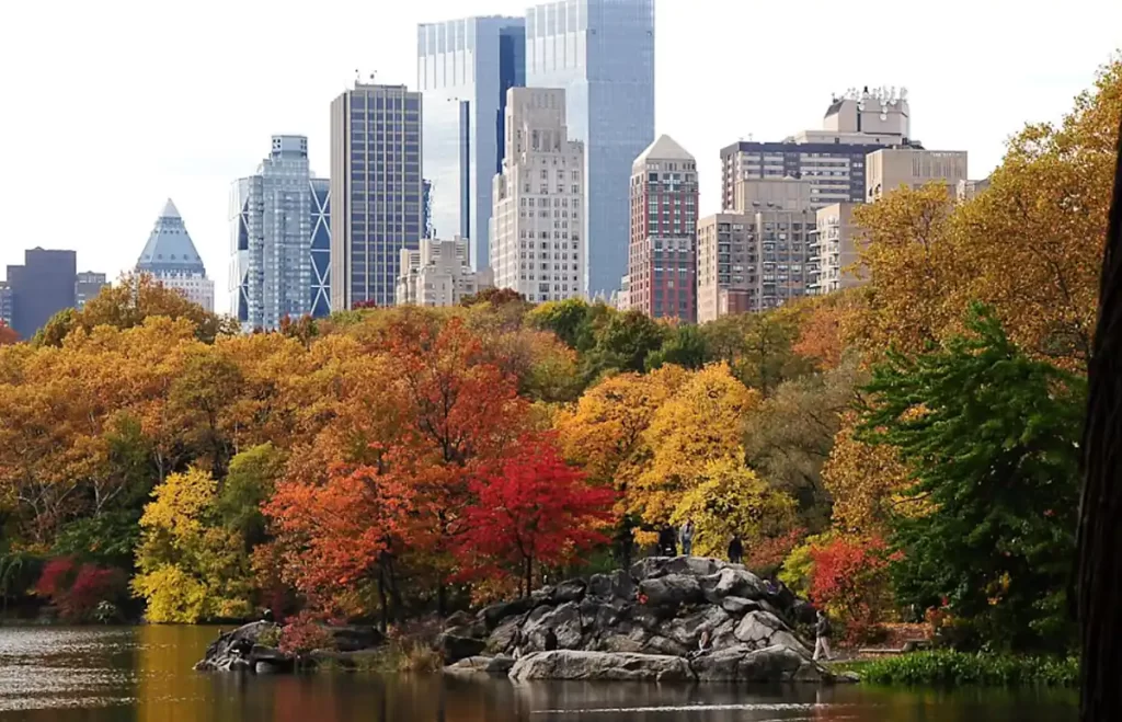 Central Park no outono com árvores coloridas e skyline de Manhattan ao fundo em Nova York