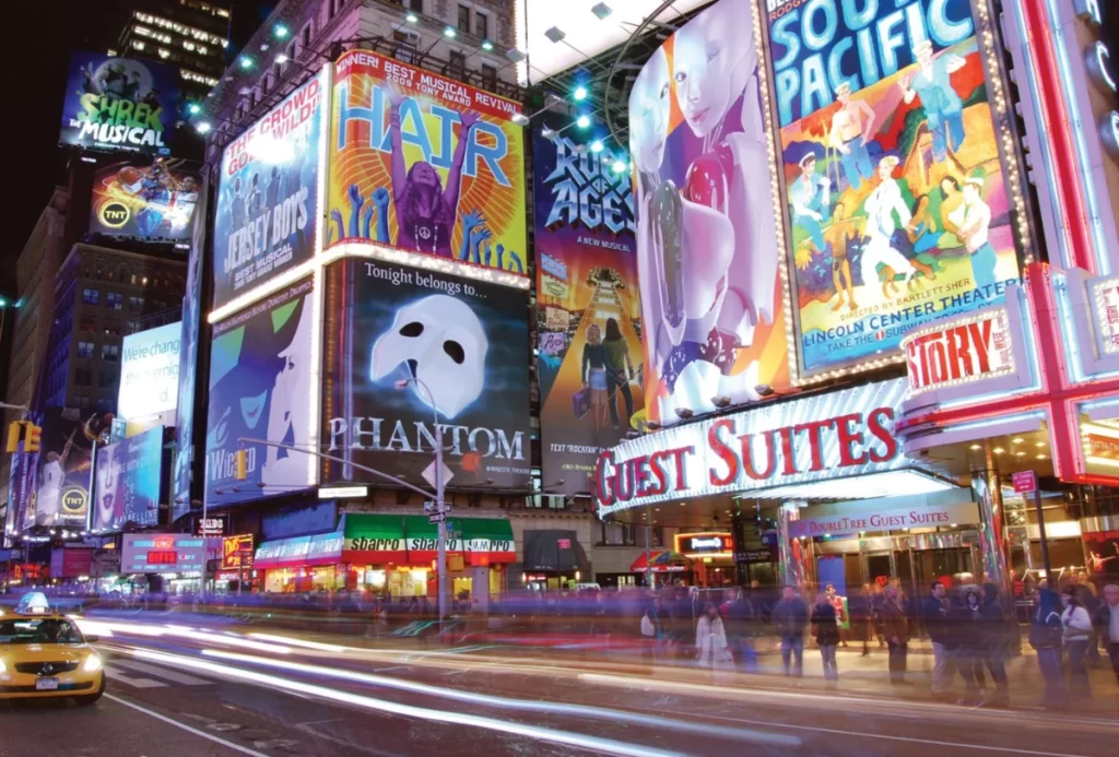 Broadway à noite com cartazes de musicais e luzes vibrantes em Nova York