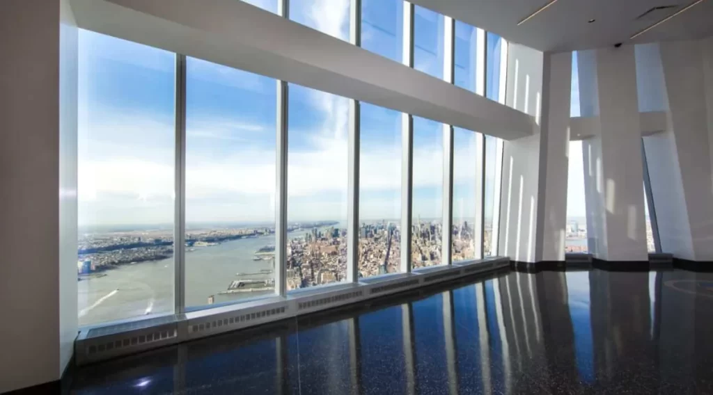 Vista interna do observatório do One World Trade Center com janelas do chão ao teto.