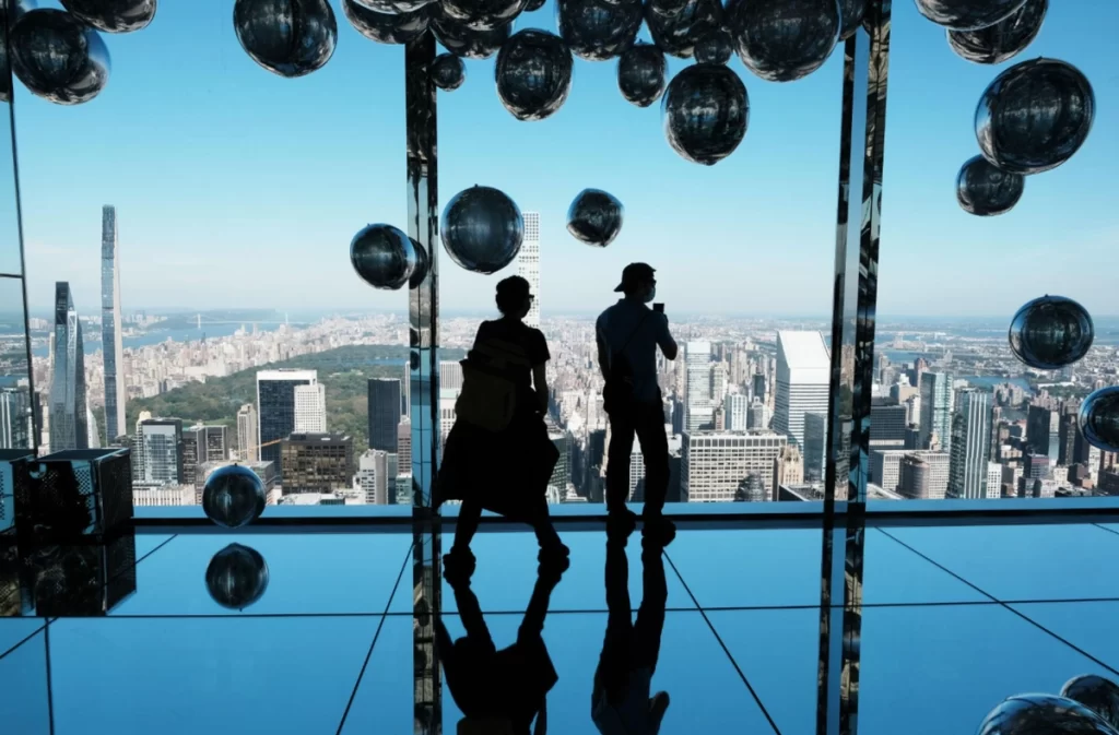 Visitantes observando o skyline de Nova York e o Central Park no Summit One New York.