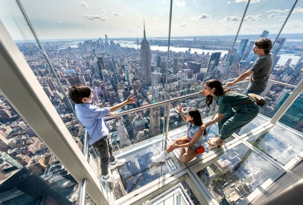 Família vivendo a experiência do skybox de vidro no Summit One New York.