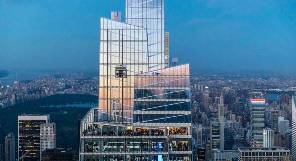 Arquitetura externa do Summit One New York com elevadores panorâmicos de vidro.