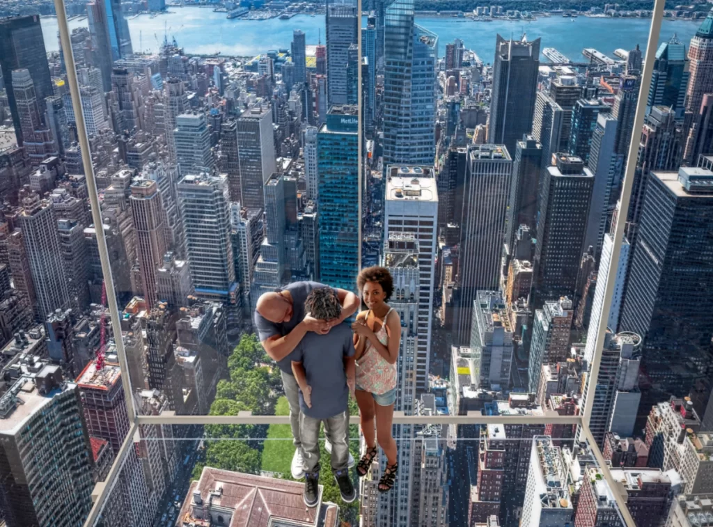 Visitantes interagindo com o chão espelhado no Summit One New York, atração imersiva em Manhattan.