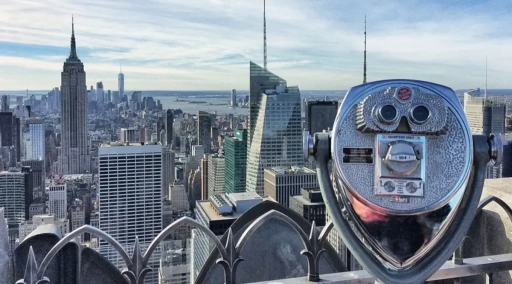 Binóculo de observação no Top of the Rock com vista privilegiada para o Empire State Building e o skyline de Manhattan em Nova York.