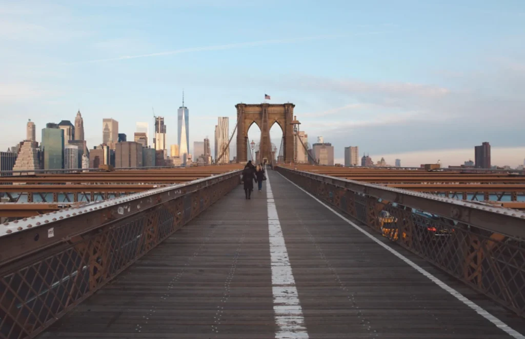 Caminho de pedestres sobre a Brooklyn Bridge em direção ao skyline de Manhattan, Nova York.