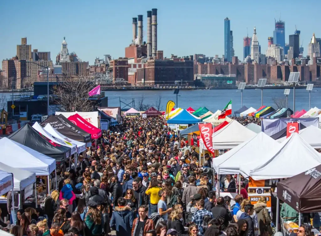 Movimento entre barracas do Brooklyn Flea com Manhattan do outro lado do East River.
