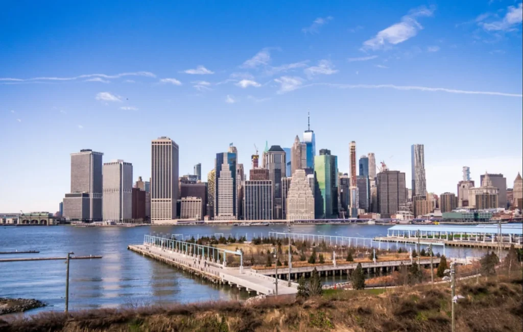 Skyline de Lower Manhattan visto do waterfront do Brooklyn em dia de céu azul.
