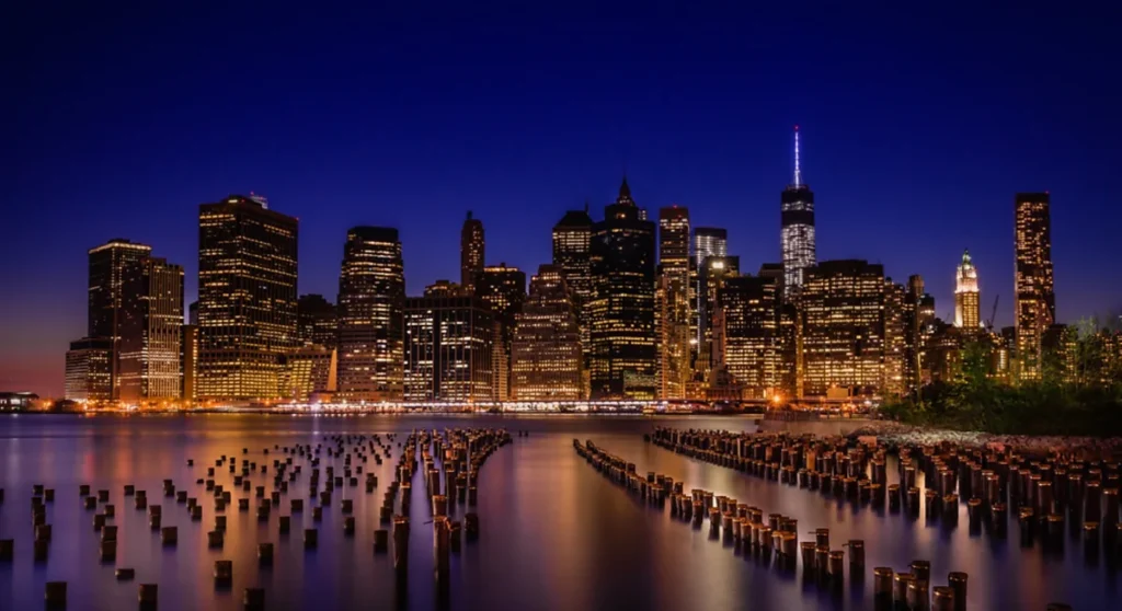 As luzes de Lower Manhattan refletem no East River em uma vista noturna a partir do Brooklyn.