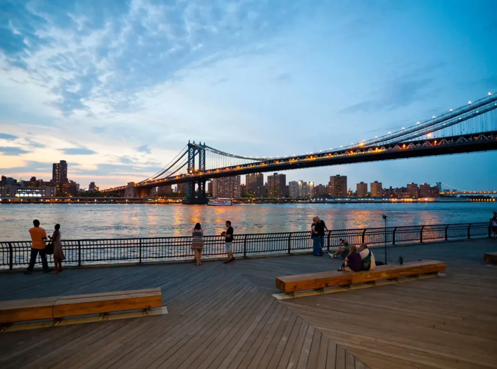 Vista da Manhattan Bridge sobre o East River ao entardecer, a partir do waterfront do Brooklyn, em Nova York.